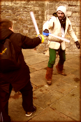 child fighting medieval man, using toy swords